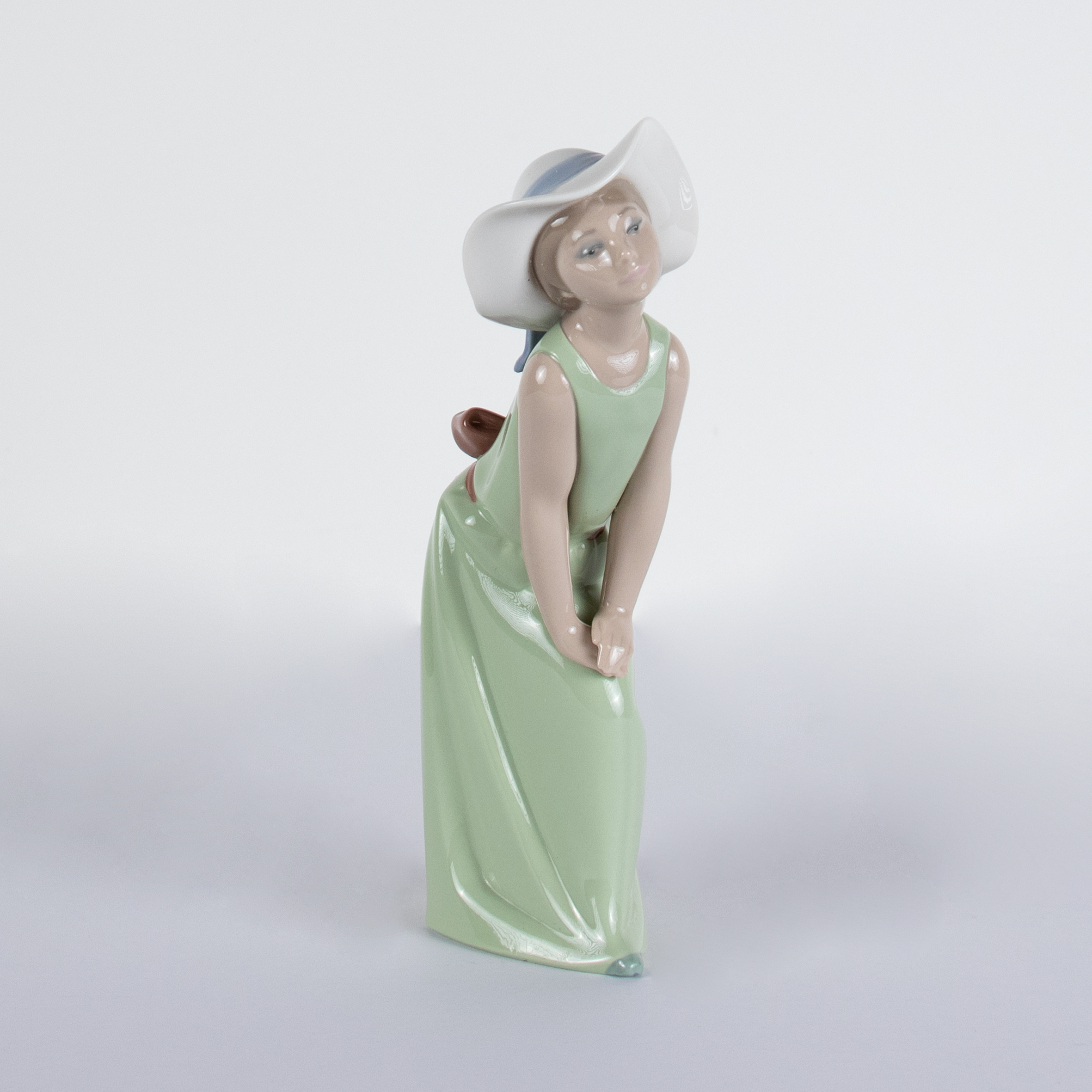 Lladró A 'Curious Girl With Straw Hat' porcelain figurine