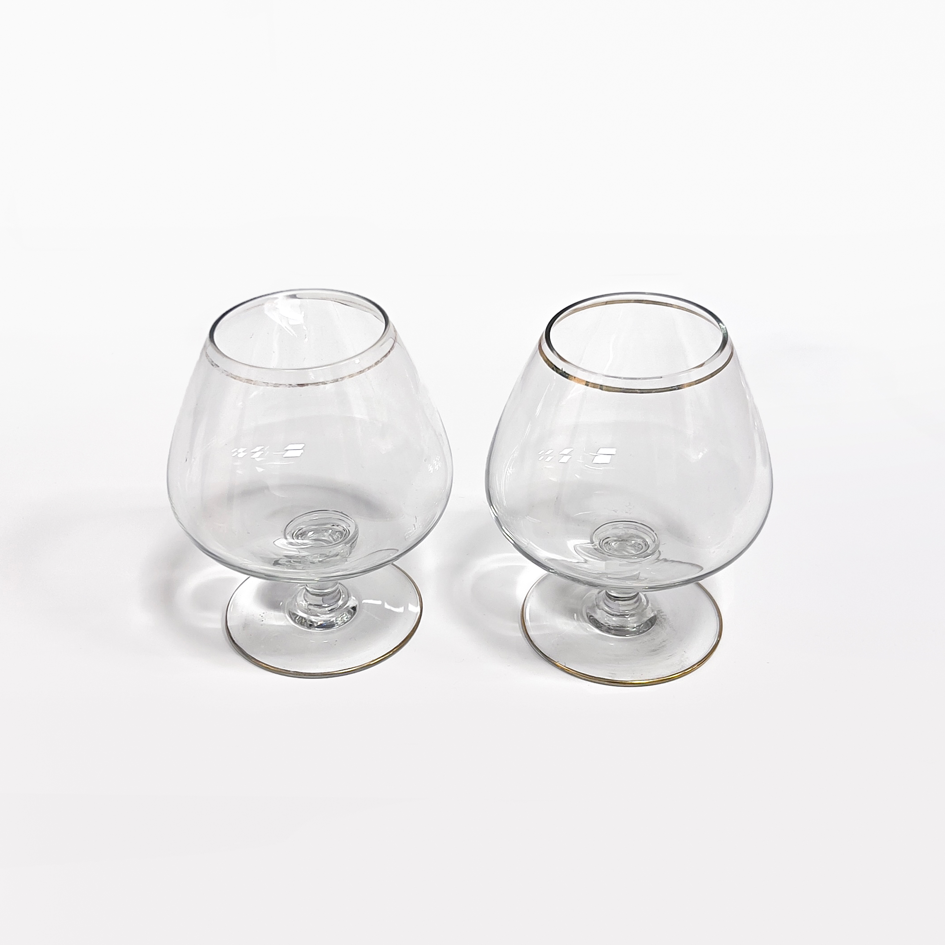  A set of 2 goldrimmed brandy glasses